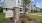 a sign in front of townhomes with a tree and grass