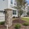 a sign in front of townhomes with a tree and grass