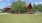 a log cabin with trees and grass