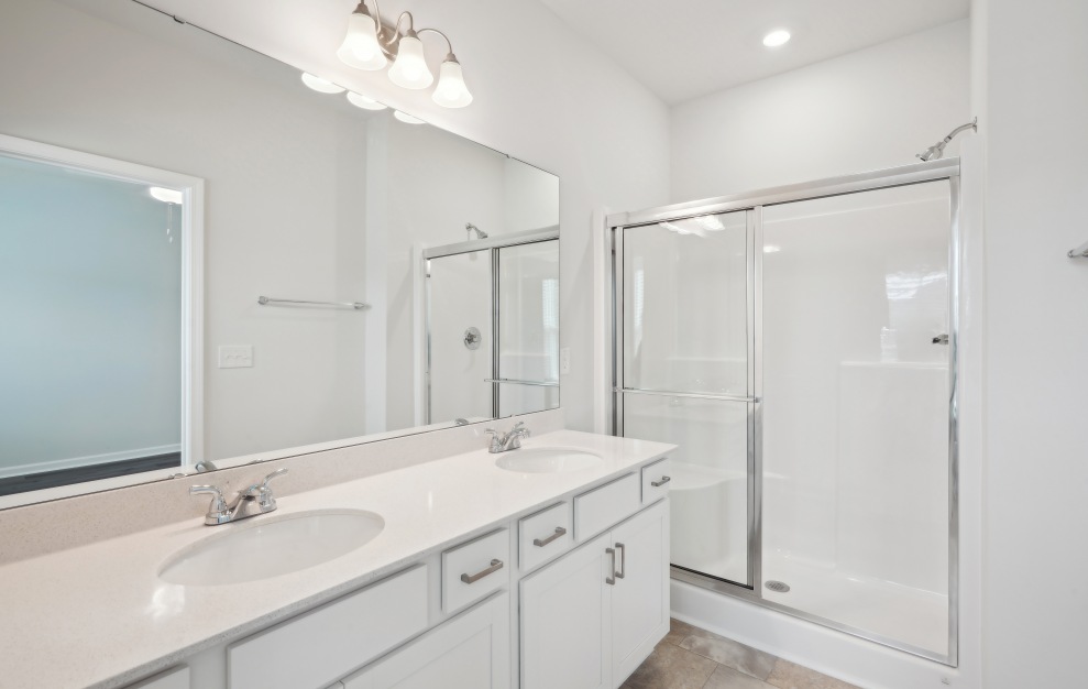 Bathroom with white cabinets, double vanities, and under mount sinks