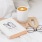 a bed with a book coffee and glasses on it